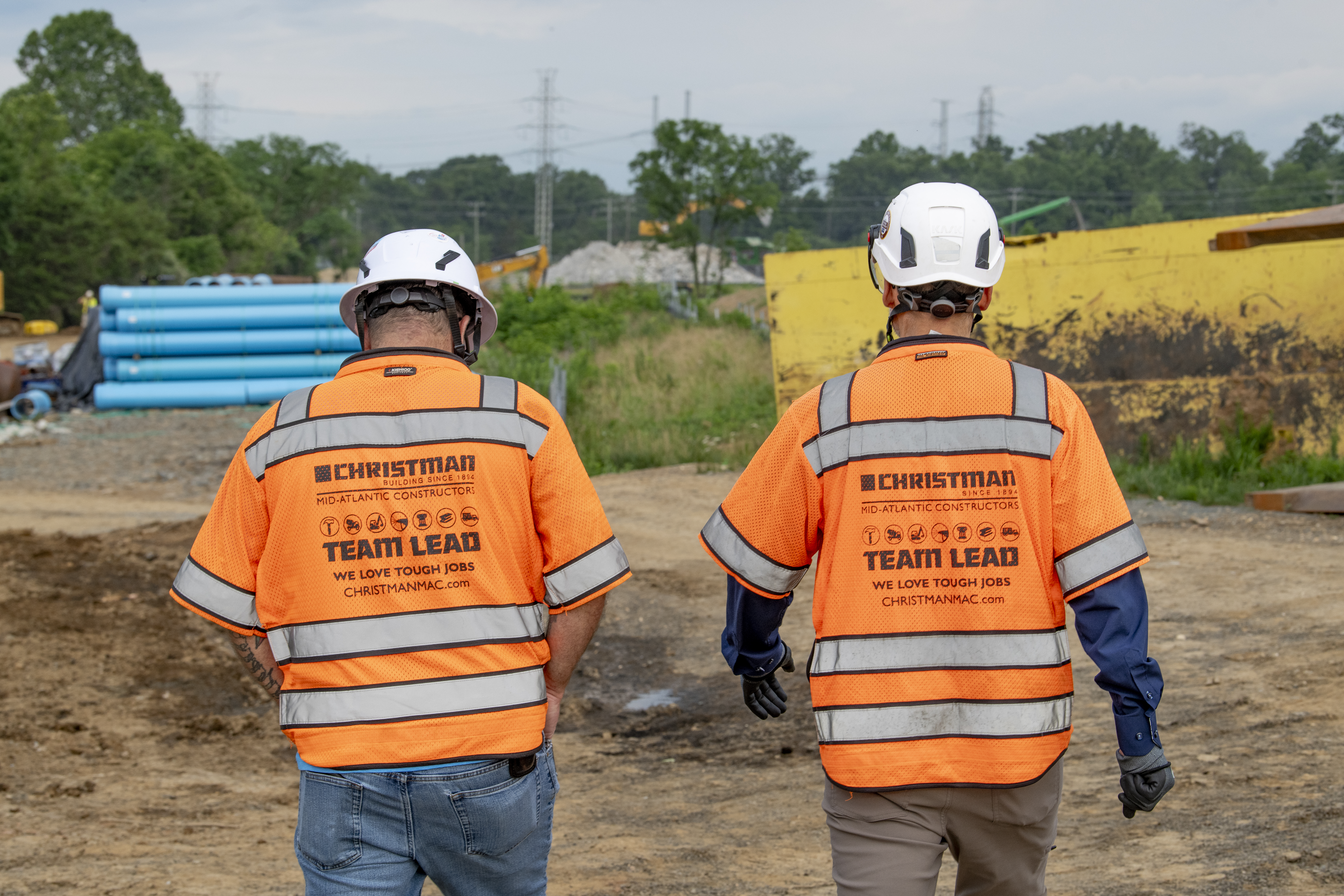 Two CMAC employees wearing PPE walking away